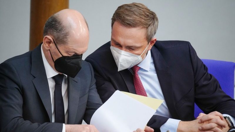 Christian Lindner (r, FDP), Bundesminister der Finanzen, und Bundeskanzler Olaf Scholz (SPD) unterhalten sich während der Sitzung des Bundestags.