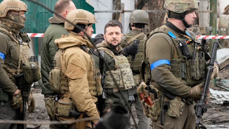 Wolodymyr Selenskyj (M), Präsident der Ukraine, begutachtet den Schauplatz eines Gefechts in Butscha.