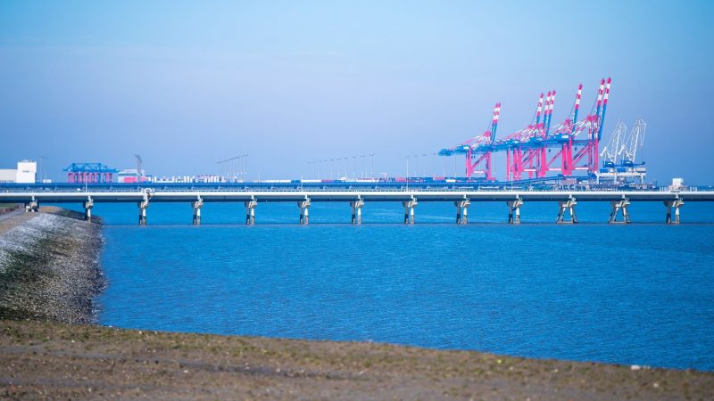 Der Jade-Weser-Port mit den Rohren der Tankerlöschbrücke im Vordergrund. Um Flüssigerdgas (LNG) über ein geplantes Importterminal in Wilhelmshaven anzulanden, soll ine rund 30 Kilometer lange Leitung vom Hafen bis ins ostfriesische Etzel (Kreis Wittmund) gebaut werden.