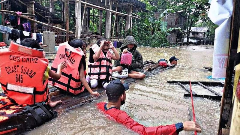 Bewohner eines überschwemmten Dorfes in Panitan auf der Insel Panay werden von Rettungskräften evakuiert.