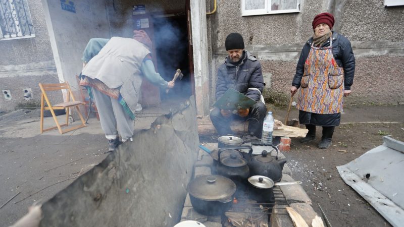Einwohner kochen in Mariupol im Freien.