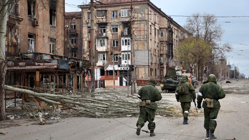 Soldaten der Miliz der «Volksrepublik» Donezk gehen an beschädigten Wohnhäusern in Mariupol vorbei.