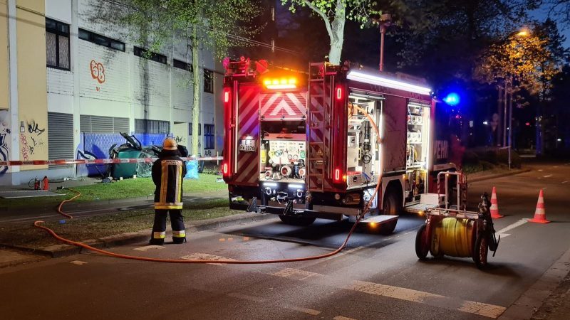 Ein Feuerwehrmann steht neben dem Wrack eines Autos, in dem zwei junge Männer aus der obersten Etage eines Parkhauses gestürzt und ums Leben gekommen sind.