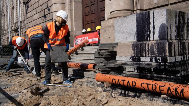 Aktivisten vom Bündnis «Letzte Generation» reißen den Gehweg vor dem Bundeswirtschaftsministerium auf, um Rohre für die symbolische Pipeline «Katar-Stream» zu verlegen.