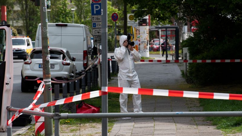 Ein Mitarbeiter der Spurensicherung dokumentiert die Lage am Tatort in der Berliner Maximilianstraße, wo eine Frau auf offener Straße getötet worden ist.