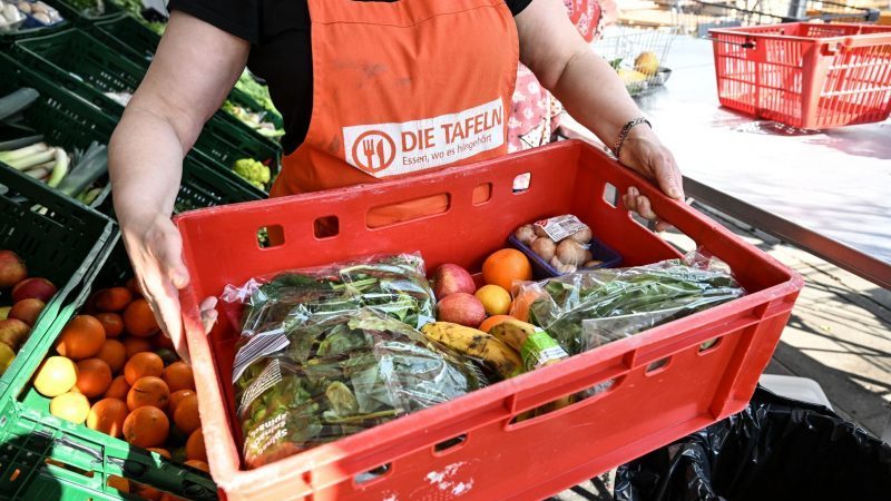 Eine Mitarbeiterin des Tafel-Ladens in Singen Am Hohentwiel trägt eine Kiste voll mit Obst und Gemüse. Für Menschen in Not sind die Tafeln in Baden-Württemberg wichtige Anlaufstellen.