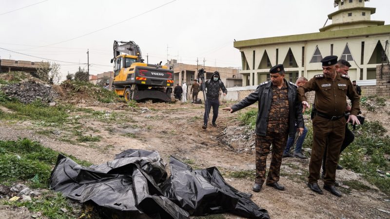 Mitglieder der Sicherheitskräfte zeigen auf einen Leichensack mit menschlichen Überresten, der in einem Massengrab im Westen von Mossul entdeckt wurde. Es wird angenommen, dass es sich dabei um die Opfer handelt, die während der Besetzung des Gebiets durch die Terrorgruppe Islamischer Staat (IS) im Jahr 2014 getötet und verscharrt wurden.