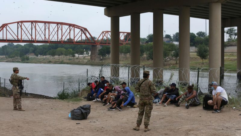 Migranten warten am Rio Grande auf die Ankunft von US-Grenzschutzbeamten. Eine Regelung der Gesundheitsbehörde CDC ermöglicht unter Verweis auf pandemiebedingte Gesundheitsrisiken, die meisten ohne gültige Papiere ins Land gelangten Menschen rasch wieder abzuschieben.