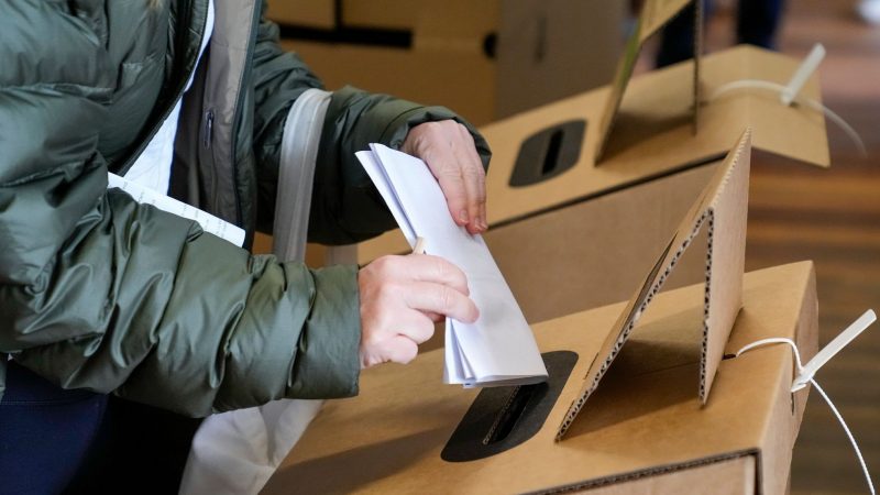 Eine Wählerin gibt ihren Stimmzettel in einer Wahlkabine in Sydney ab.
