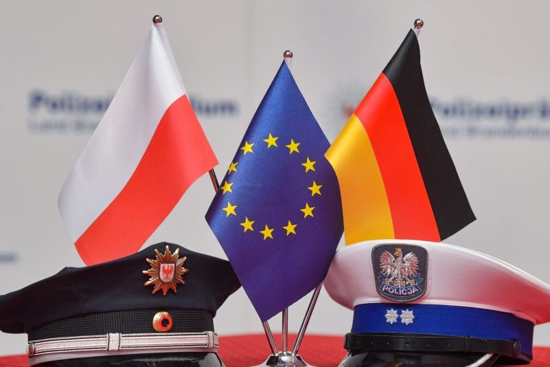 Fähnchen von Polen, der EU und Deutschland (l-r). Polnische Polizisten haben einen Mann in Polen festgenommen, der in Deutschland ein Kind getötet haben soll.