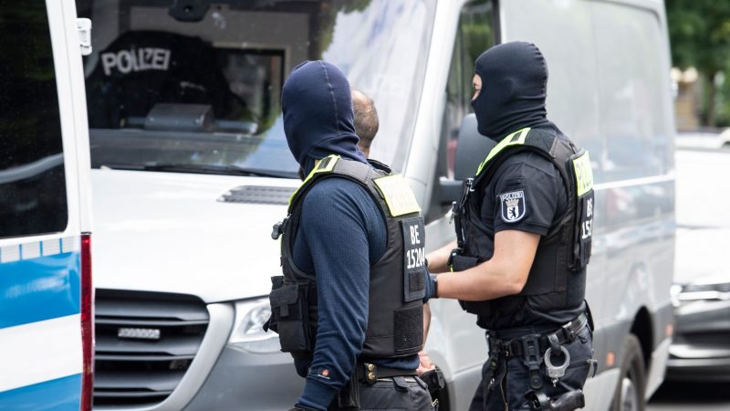 Polizisten führen einen Mann ab. Mit einer  Razzia ist die Polizei in Berlin gegen den organisierten Drogenhandel vorgegangen.