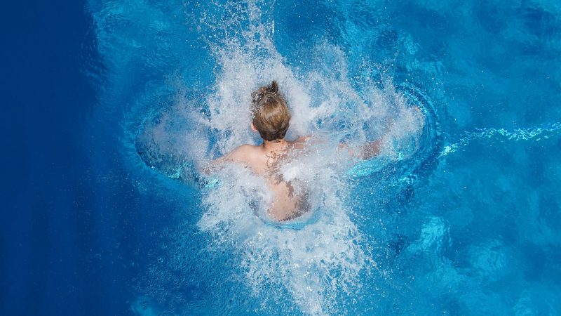 Abkühlung gesucht: Nach einem Sprung vom 5-Meter-Turm taucht ein Junge bei sommerlichen Temperaturen im Berliner Olympiabad ins Wasser ein.