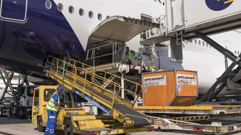 Mitarbeiter von Fraport verladen auf dem Flughafen Frankfurt eine Box in einen Airbus A380.
