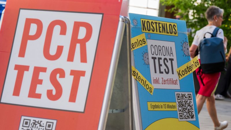 Schilder bewerben vor dem Eingang einer Apotheke in der Münchener Innenstadt Corona-Tests.