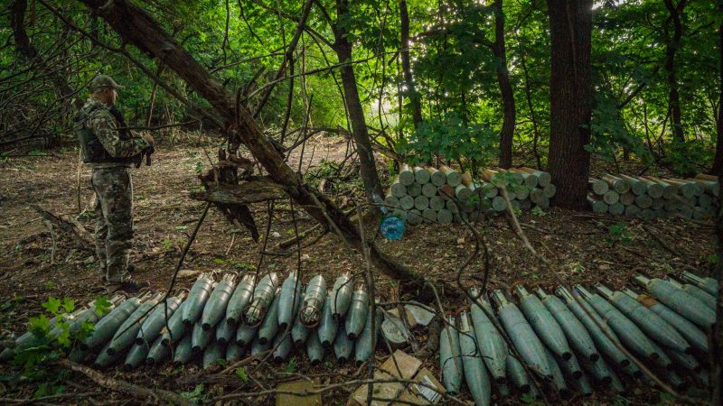 Ein ukrainischer Soldat steht neben in den Wäldern nahe der Provinz Saporischschja versteckten Haubitzen-Munition, die für den Beschuss der russischen Stellungen vorbereitet wurden.