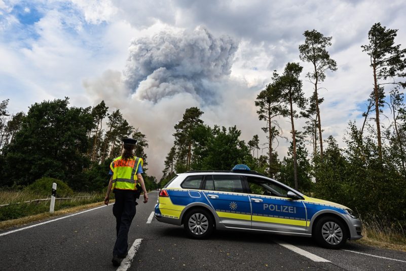 Ein Polizeiauto sperrt die Straße im Waldbrandgebiet in der sächsischen Gohrischheide ab.