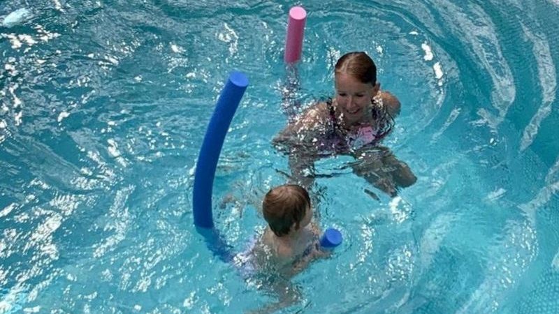 Diplom-Sportlehrerin und Schwimmtrainerin Marion Bösel-Weßler übt mit einem Keinkind in einem Becken Schwimmen.