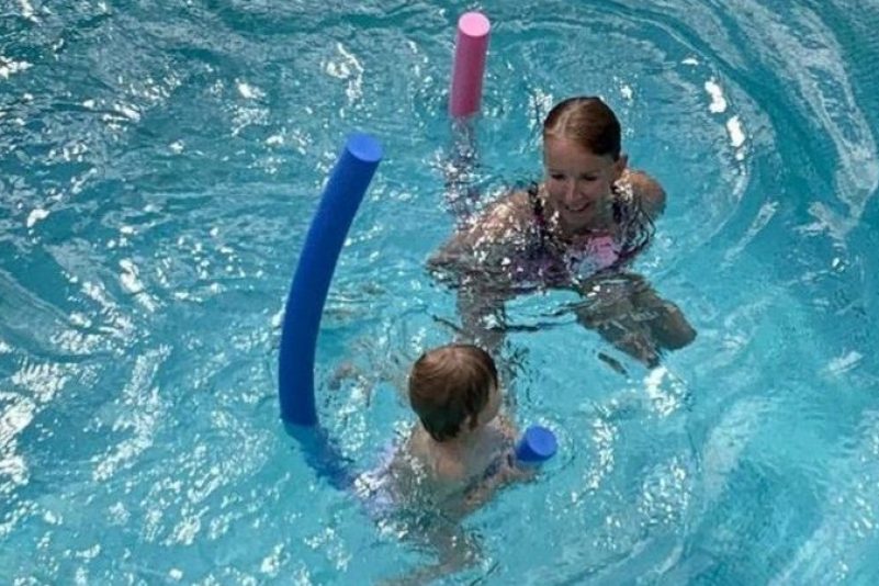 Diplom-Sportlehrerin und Schwimmtrainerin Marion Bösel-Weßler übt mit einem Keinkind in einem Becken Schwimmen.