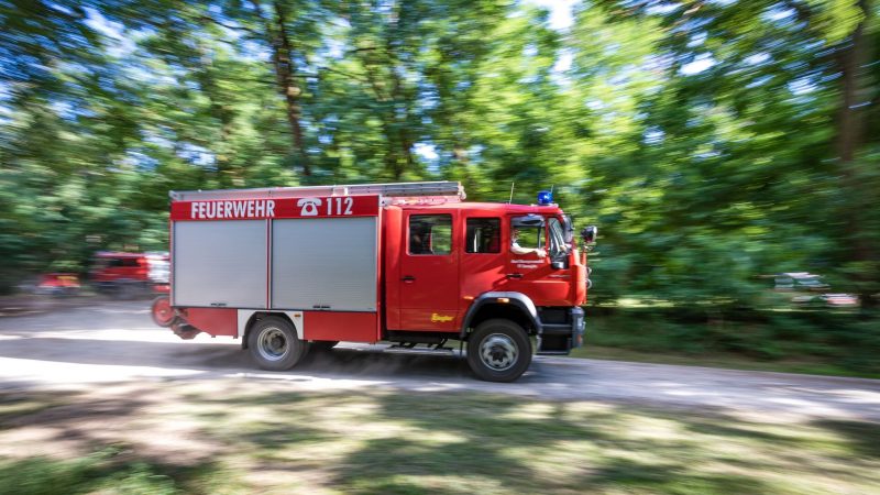 Ein Fahrzeug der Feuerwehr fährt in der Nähe des Einsatzortes: Die Einsatzkräfte scheinen den Waldbrand in der Lieberoser Heide nun im Griff zu haben.
