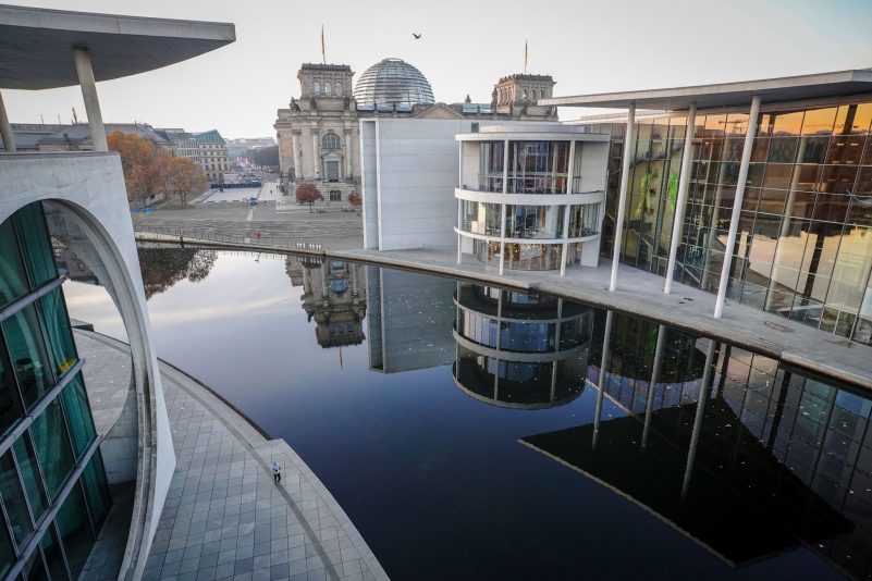 Das Paul-Löbe-Haus und das Reichstagsgebäude spiegeln sich am frühen Morgen vor Beginn der Bundestagssitzung in der Spree.