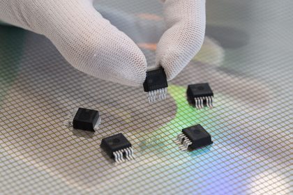 Eine Mitarbeiterin präsentiert in der Halbleiterfabrik von Bosch in Dresden  mikromechanische Sensoren über einem 300-Millimeter-Wafer.