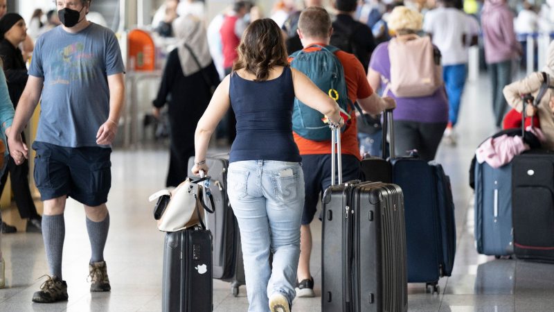 Passagiere warten auf dem Flughafen in Frankfurt am Main auf ihren Check-In.