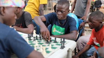 Der 17-Jährige Ayomide Ojo (m.) am Schachbrett pielt bei einem Treffen der Organisation «Chess in Slums».