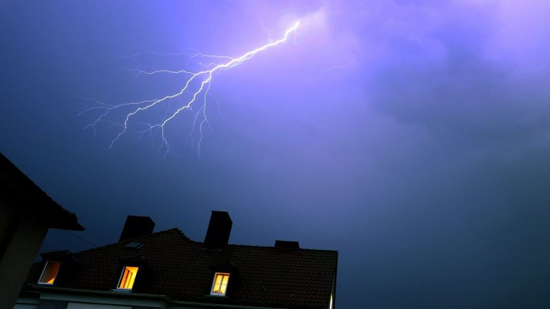 Blitze entladen sich über einem Wohnhaus in Würzburg. Nach der großen Hitze warnt der Deutsche Wetterdienst vor heftigen Gewittern.