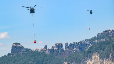 Hubschrauber der Bundeswehr helfen mit Löschwasser-Außenlastbehältern den Waldbrand im Nationalpark Sächsische Schweiz zu löschen.