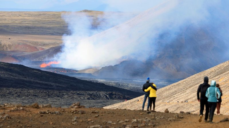 Einige Menschen beobachten den isländischen Vulkan Fagradalsfjall, der wieder ausgebrochen ist.