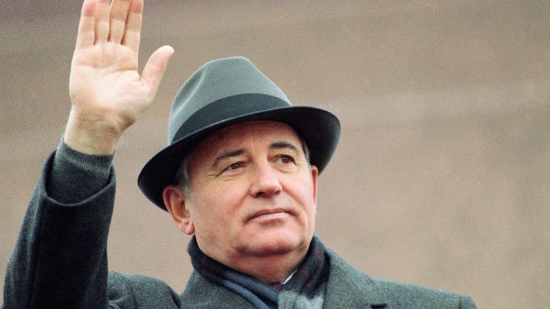 Michail Gorbatschow, damals sowjetischer Präsident, winkt während einer Feier zum Tag der Revolution von der Tribüne des Roten Platzes in Moskau.
