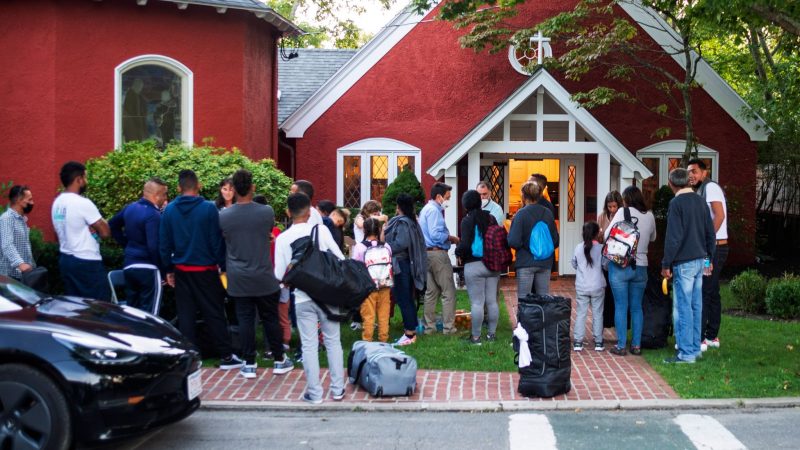 Einwanderer stehen mit ihren Habseligkeiten vor der St. Andrews-Kirche auf Martha's Vineyard.