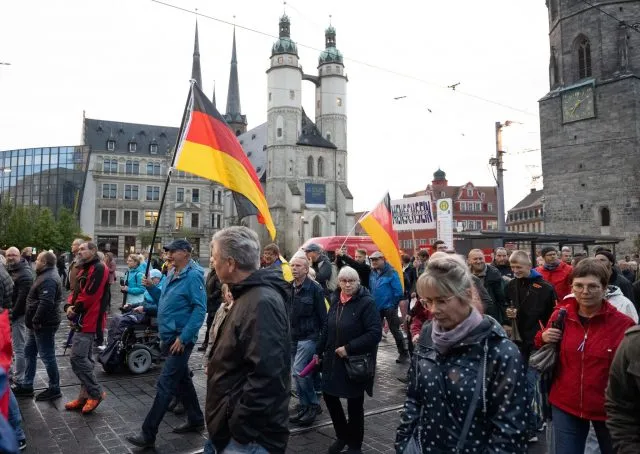 Teilnehmer einer Demonstration des Bündnisses „Bewegung Halle“ ziehen durch Halle/Saale.