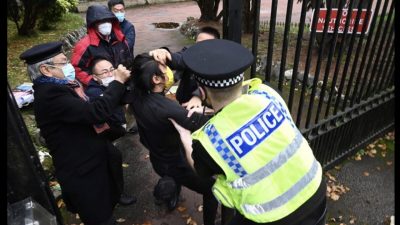Ein britischer Polizist versucht, Bob aus dem Gelände des chinesischen Konsulats in Manchester herauszuholen, nachdem er hineingezogen und geprügelt wurde.