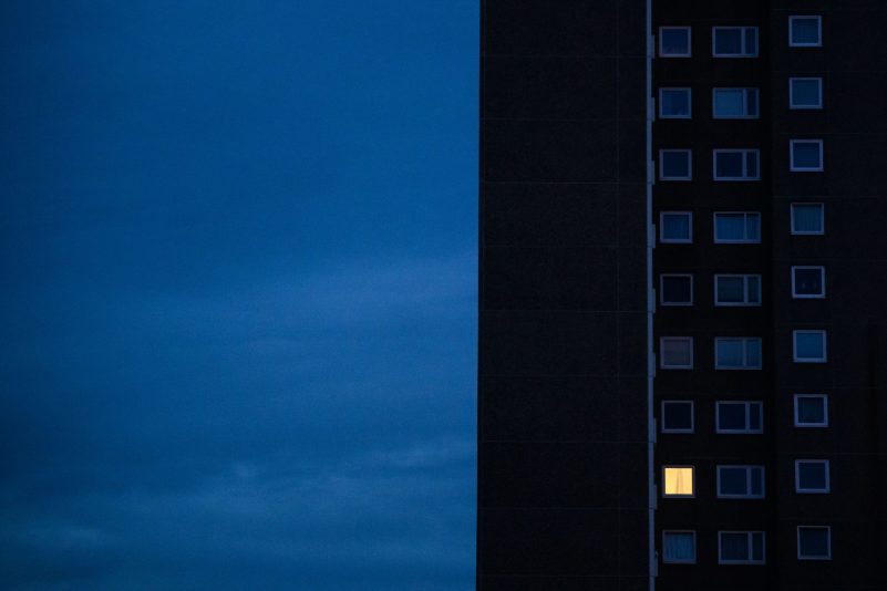Nur einer Wohnung eines Mehrfamilienhauses brennt am frühen Morgen Licht. Die teils massiv gestiegenen Preise für Gas und Strom bereiten viele Menschen in Deutschland finanzielle Schwierigkeiten.