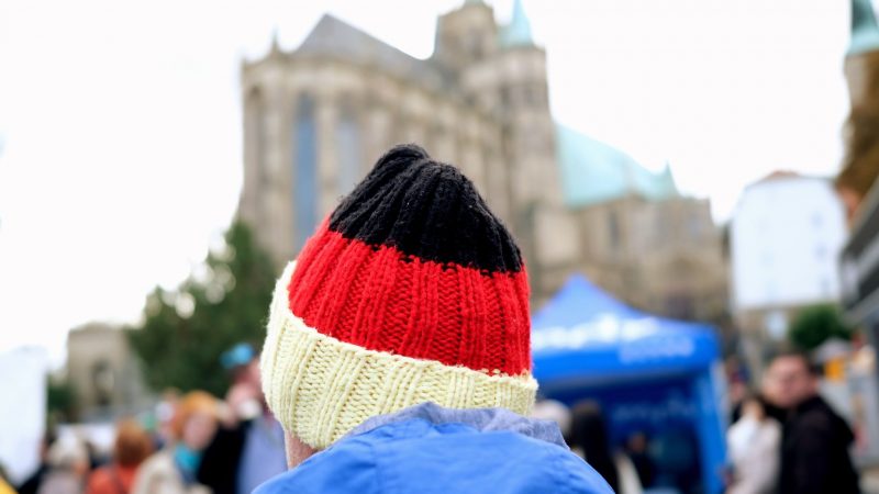 Ein Besucher des Bürgerfestes zum Tag der Deutschen Einheit trägt auf dem Domplatz eine schwarz-rot-goldene Mütze.