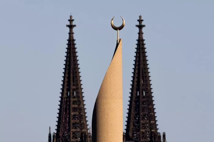 Der Kölner Dom und ein Minarett der Zentralmoschee der DITIB (Türkisch-Islamische Union der Anstalt für Religion) sind im Licht der untergehenden Sonne zu sehen.