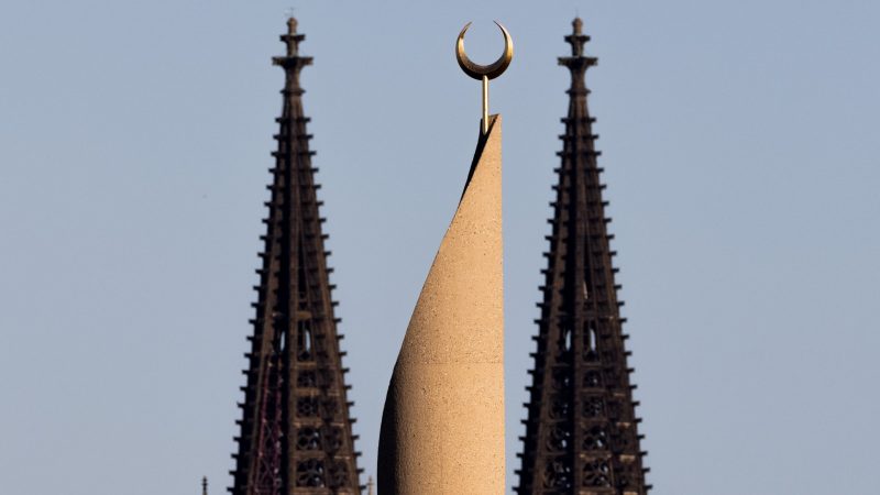 Der Kölner Dom und ein Minarett der Zentralmoschee der DITIB (Türkisch-Islamische Union der Anstalt für Religion) sind im Licht der untergehenden Sonne zu sehen.