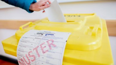 Eine Wählerin wirft ihren Stimmzettel in einem Wahllokal in Hannover in eine Wahlurne.