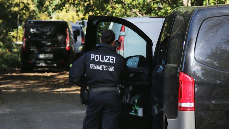 Eine Kriminaltechnikerin steht in der Nähe vom S-Bahnhof Hohenschönhausen neben Fahrzeugen der Polizei. Die Bahn wurde Opfer eines gezielten Angriffs.