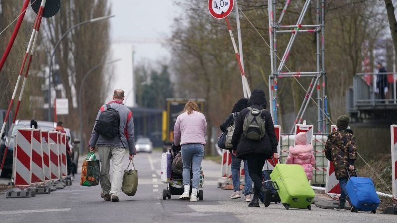 Ukrainische Flüchtlinge verlassen mit ihrem Gepäck die Flüchtlingsunterkunft in Hamburg.