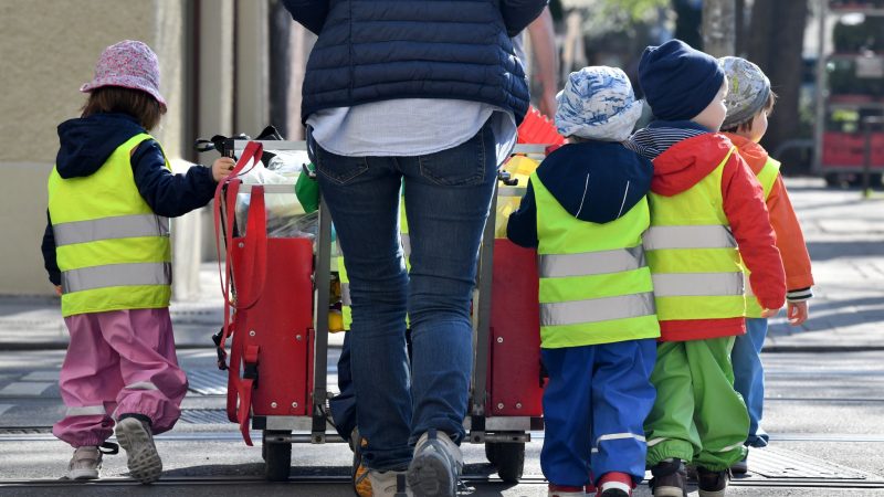 Ein Betreuerin läuft mit mehreren Kleinkindern durch München.