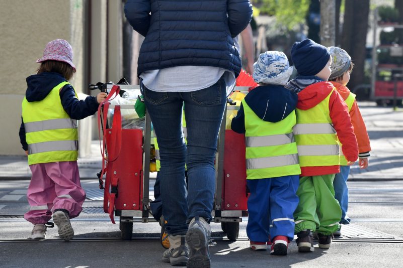 Ein Betreuerin läuft mit mehreren Kleinkindern durch München.