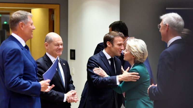 Emmanuel Macron begrüßt Ursula von der Leyen neben Bundeskanzler Olaf Scholz vor einem Treffen am Runden Tisch am zweiten Tag eines EU-Gipfels.