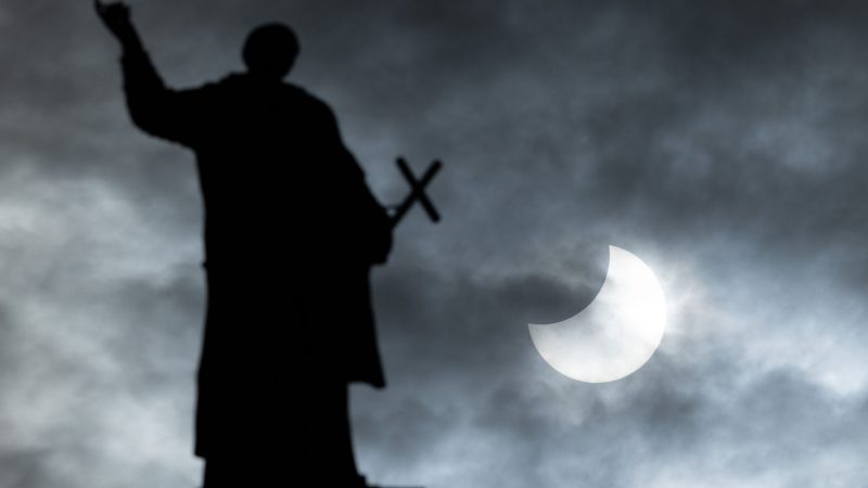 Bei einer partiellen Sonnenfinsternis wird die Sonne teilweise vom Mond verdeckt. Im Vordergrund ist eine Mattielli-Statue auf der Katholischen Hofkirche in Dresden zu sehen.
