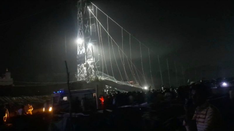 Rettungskräfte sind bei Dunkelheit im Einsatz, nachdem eine Brücke über dem Machchu-Fluss eingestürzt ist.