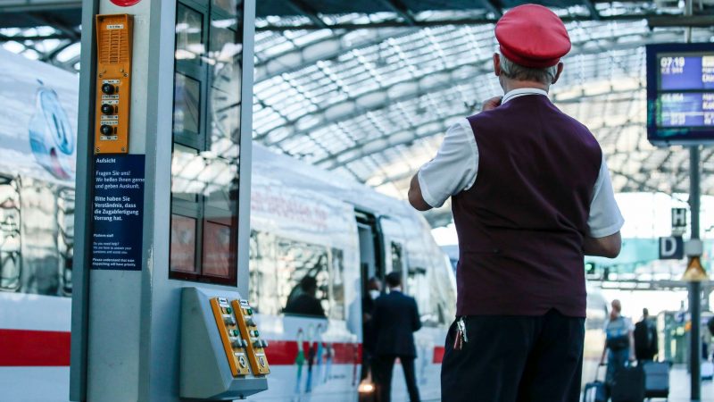 Ein Zugbegleiter gibt ein Abfahrtszeichen für einen ICE auf dem Bahnsteig im Berliner Hauptbahnhof.