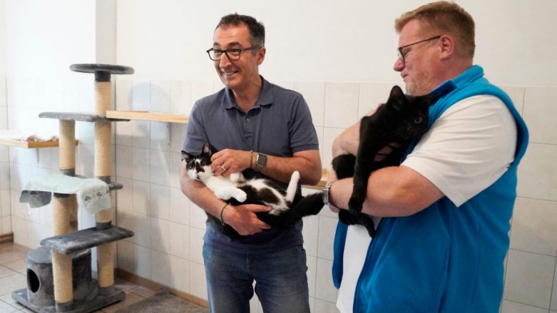 Bundeslandwirtschaftsminister Cem Özdemir (L) hält bei seinem Besuch in einem Tierheim eine Katze, während der Präsident des Tierschutzbundes (Tierschutzbund) Thomas Schroeder (R) neben ihm steht. Foto: Chiara DAZI/AFP via Getty Images