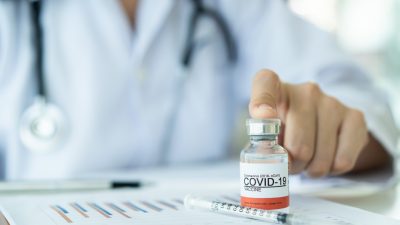 Arzt zeigt auf COVID-19-Impfstoff