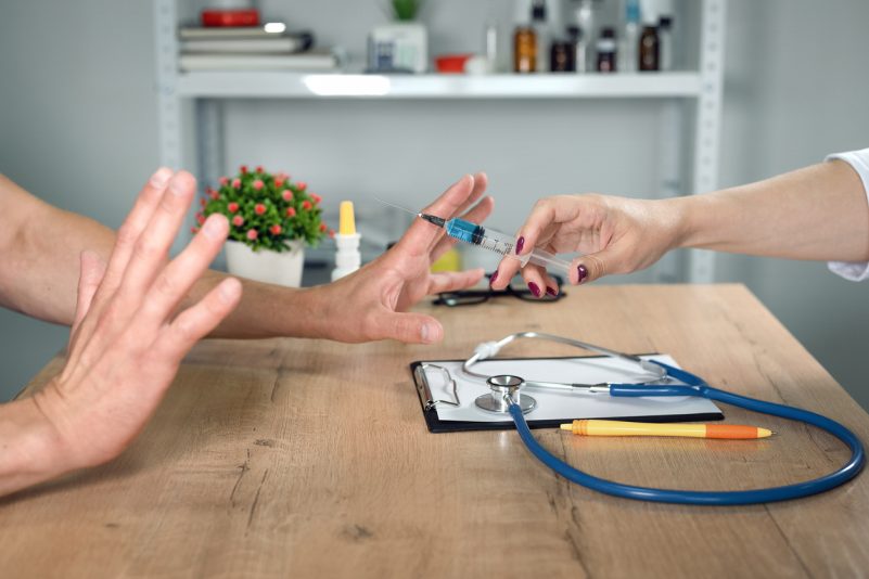 Ein Patient lehnt eine Impfspritze ab Foto: HappyNati/iStock